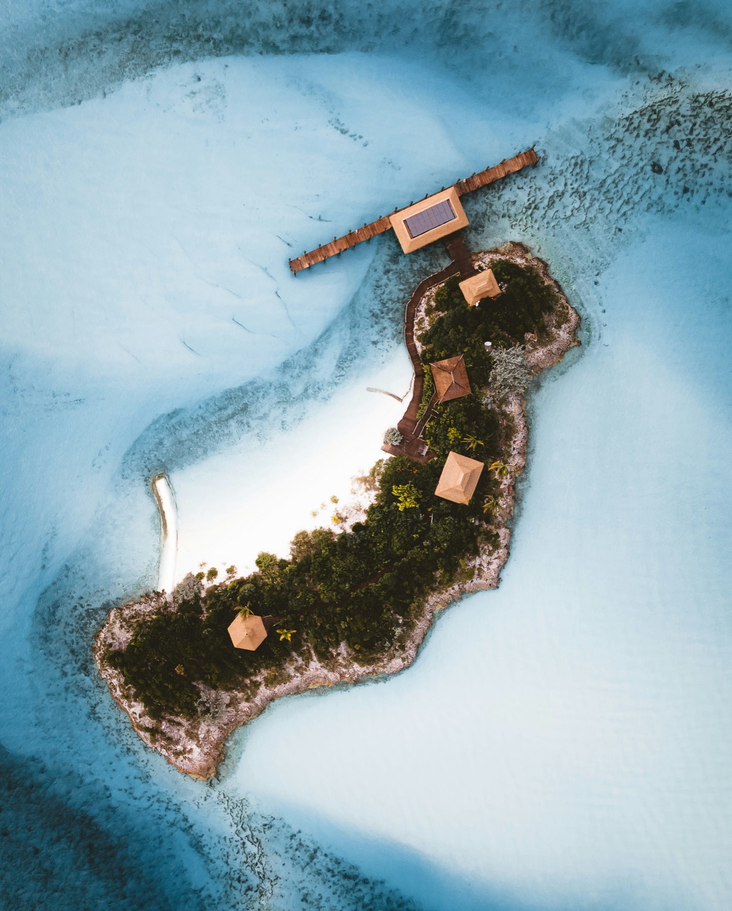 Aerial view of a tropical private island surrounded by coral reef