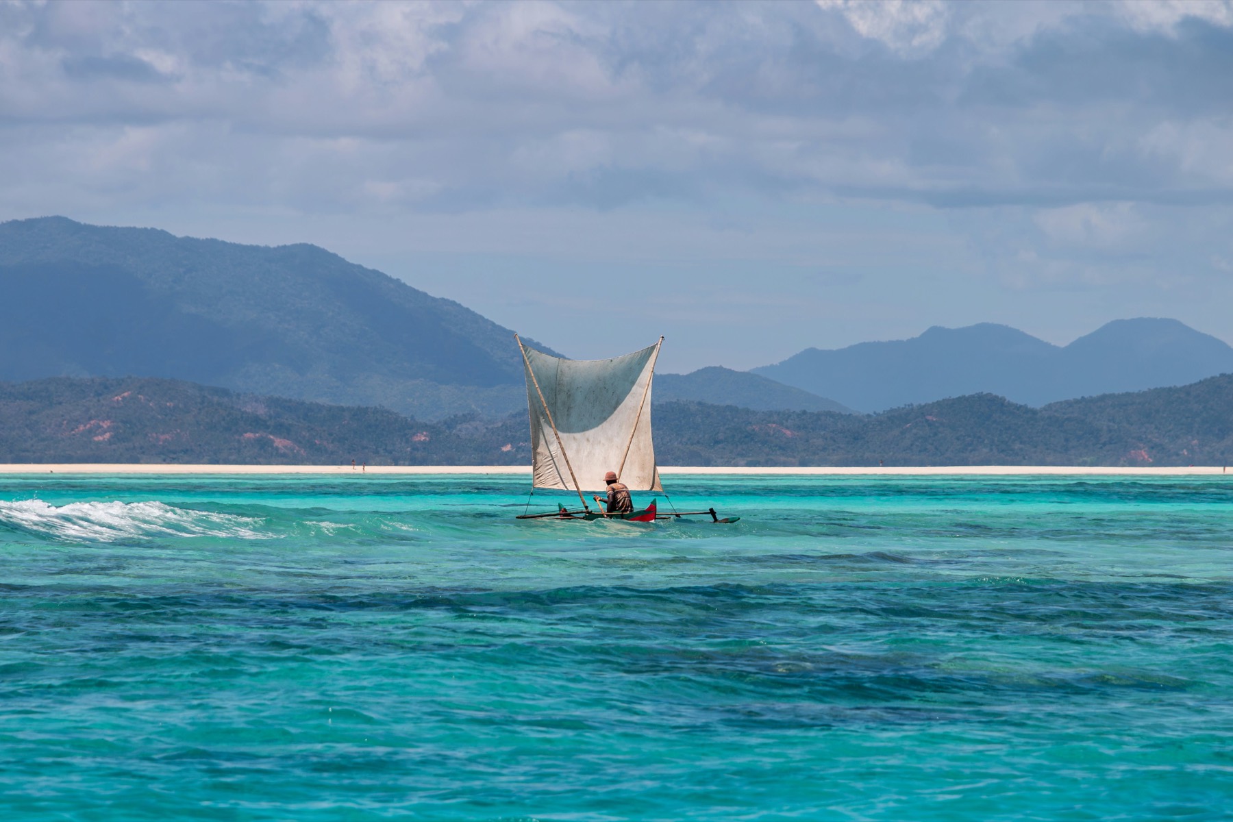 Turquoise sea and coral reef around a remote island reached on a Madagascar cruise