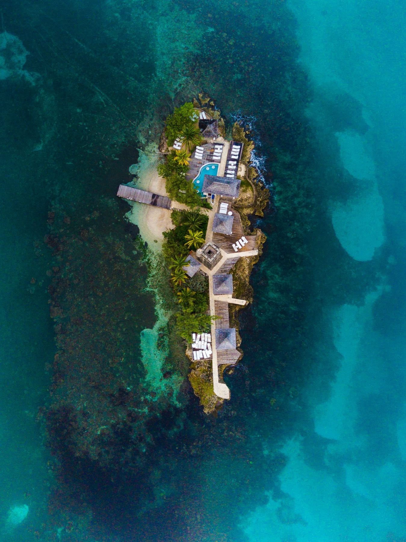 Aerial view of a secluded single-resort private island holidays destination surrounded by turquoise water