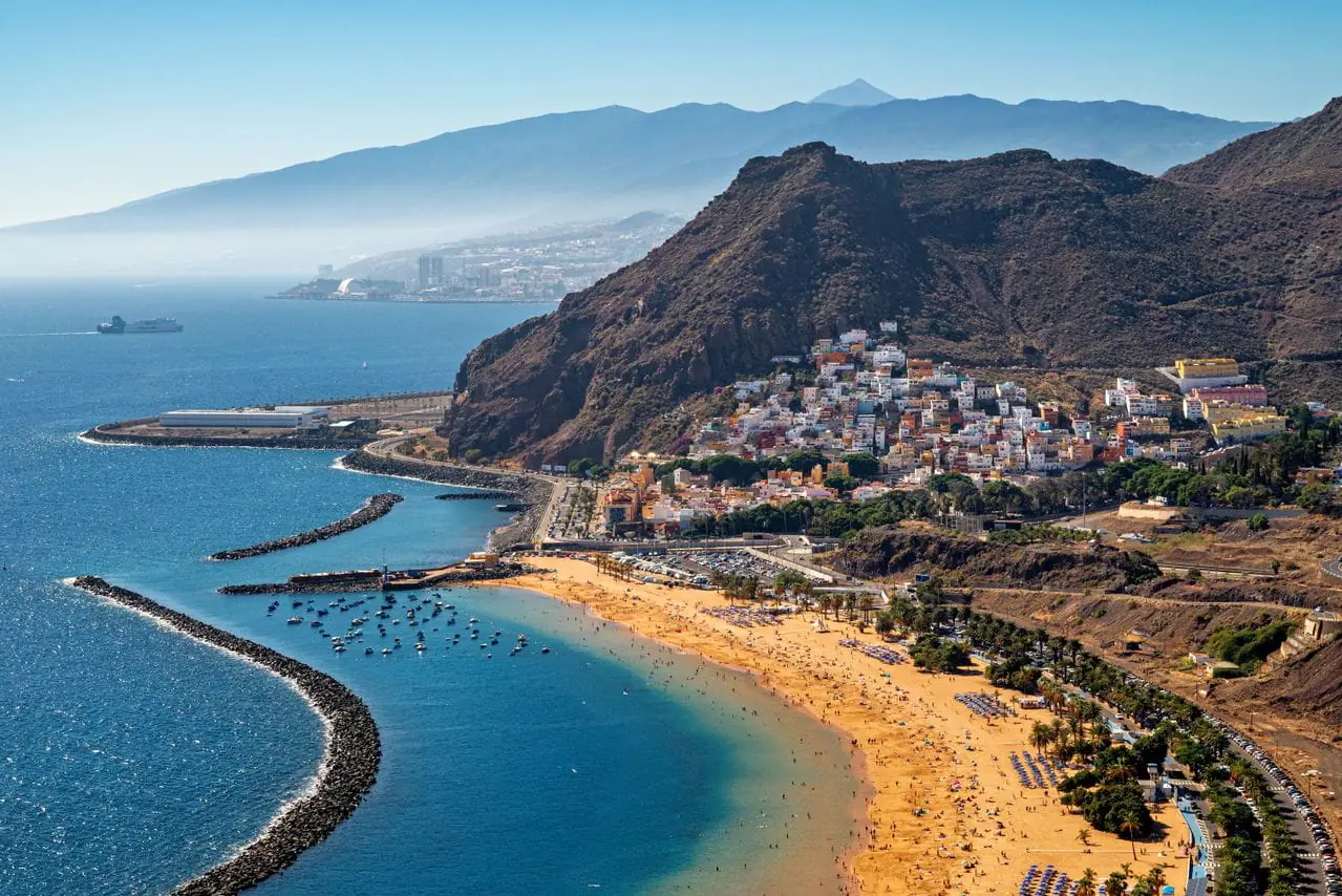 The golden sands of Playa de las Teresitas with San Andres village and Mount Teide beyond, Tenerife, Canary Islands