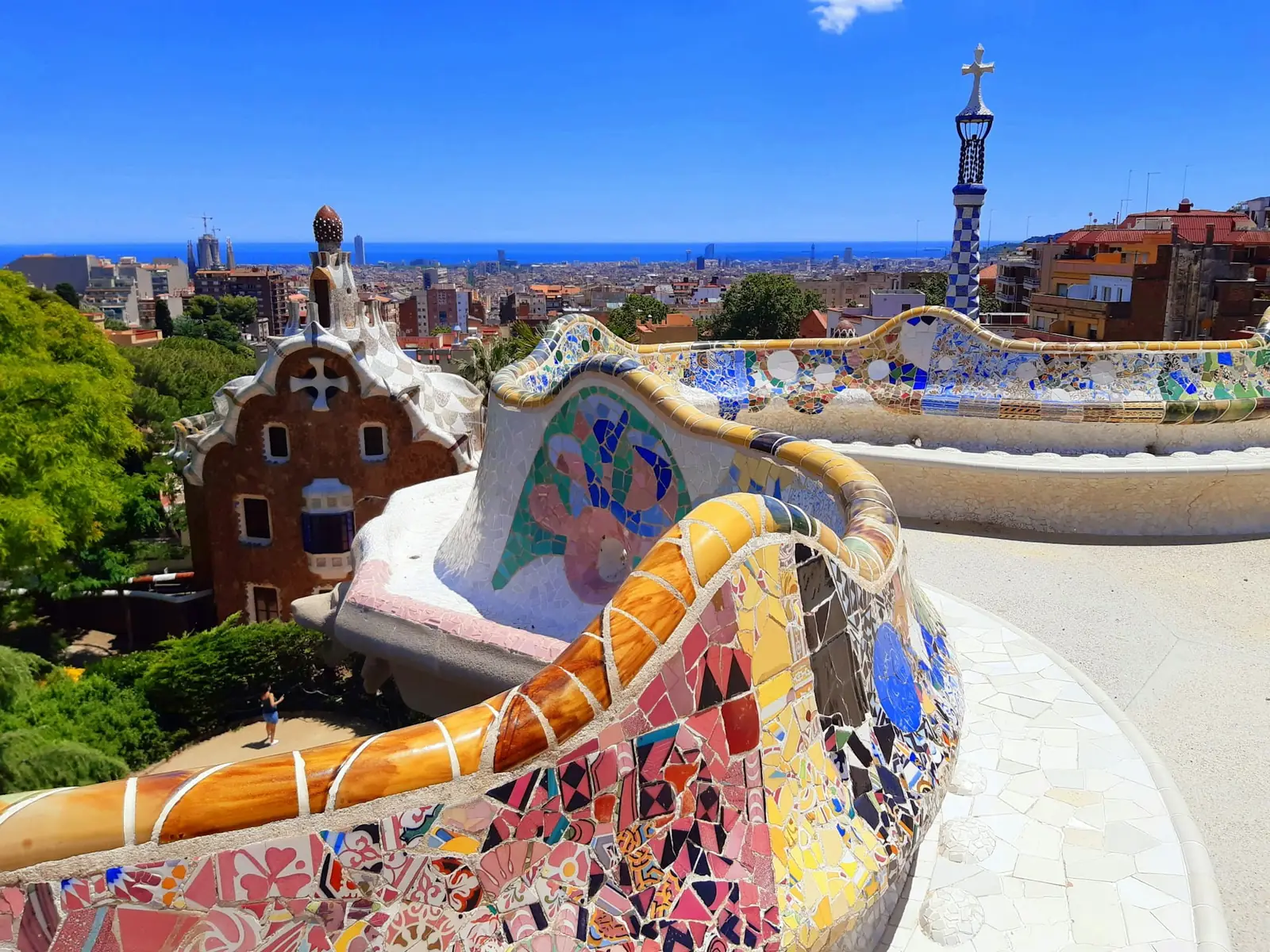 Gaudi's mosaic serpentine terrace at Park Guell overlooking Barcelona and the sea, Spain