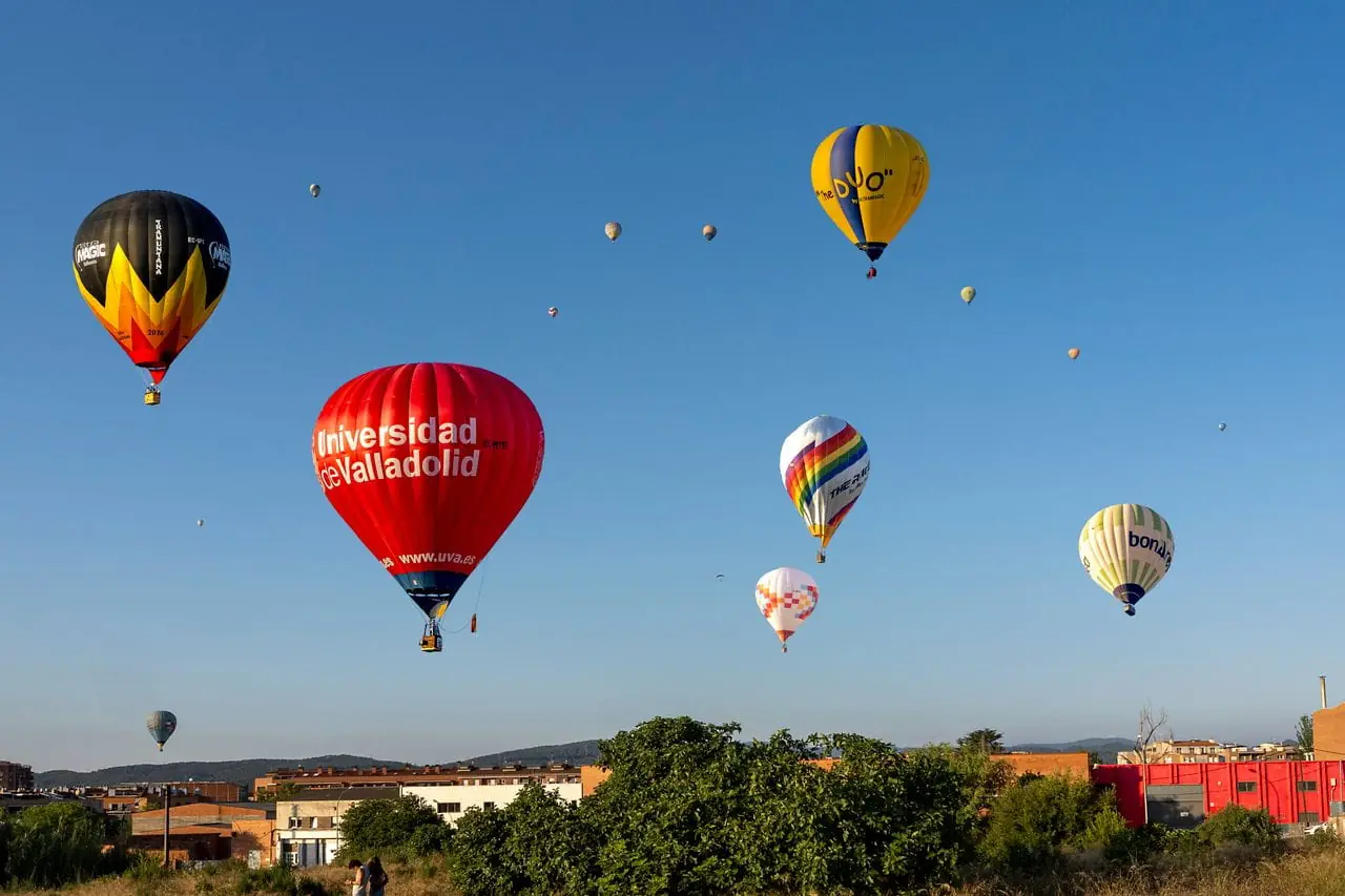 Colourful hot-air balloons rising over the countryside on a family holiday in Spain