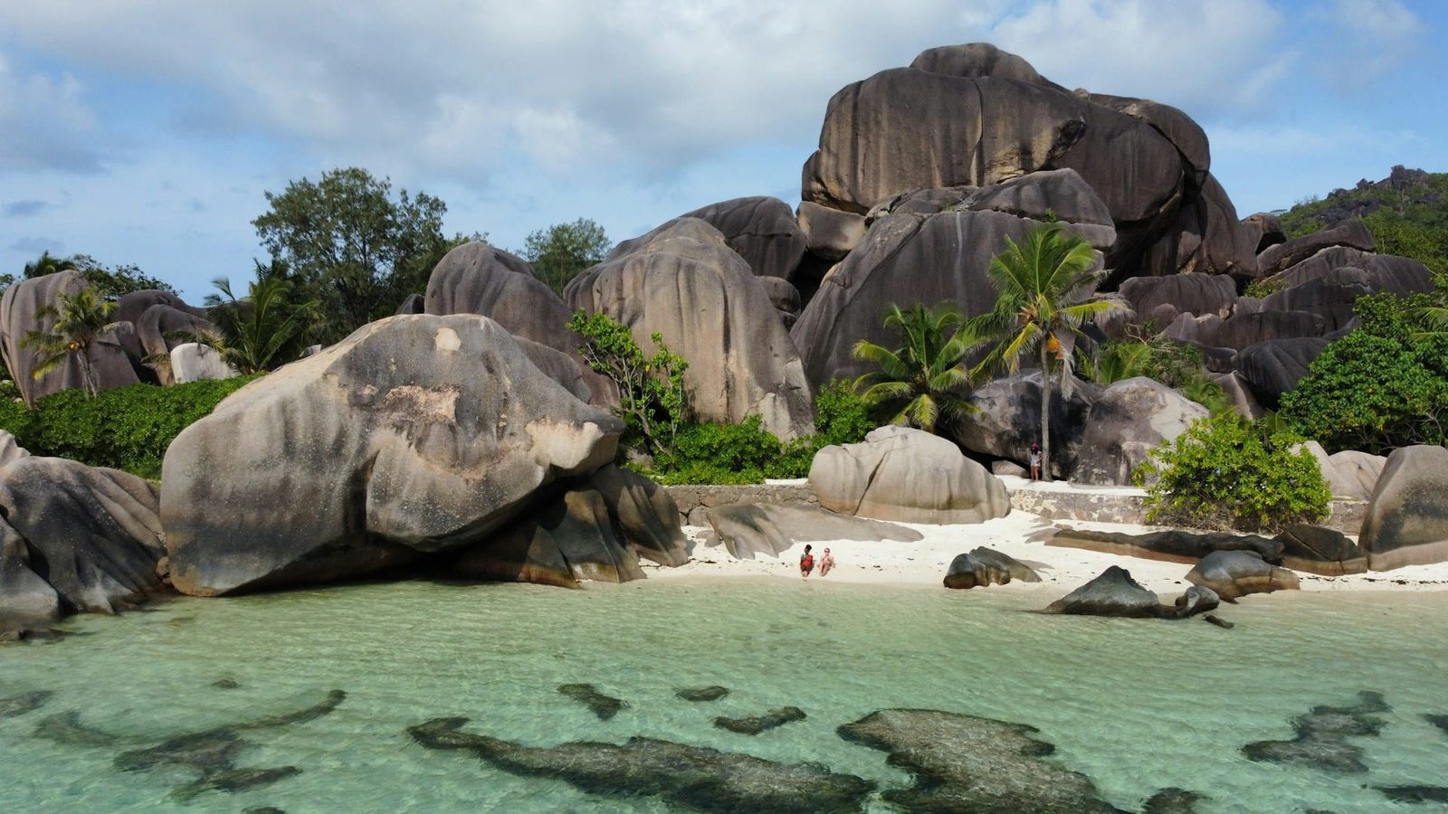 A secluded white-sand beach framed by giant granite boulders on Félicité island, Seychelles
