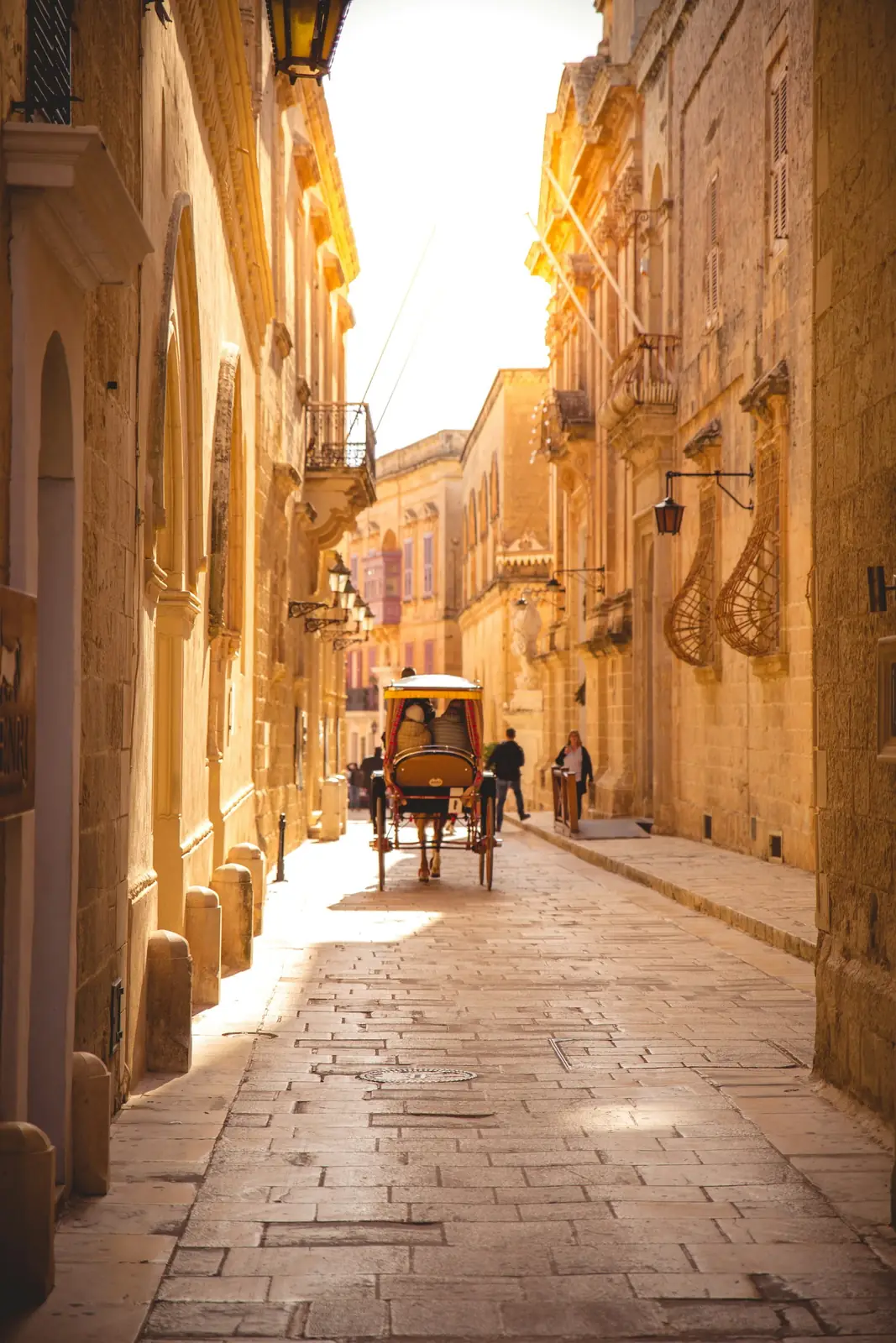 A horse-drawn carriage on a golden medieval lane in Mdina, Malta