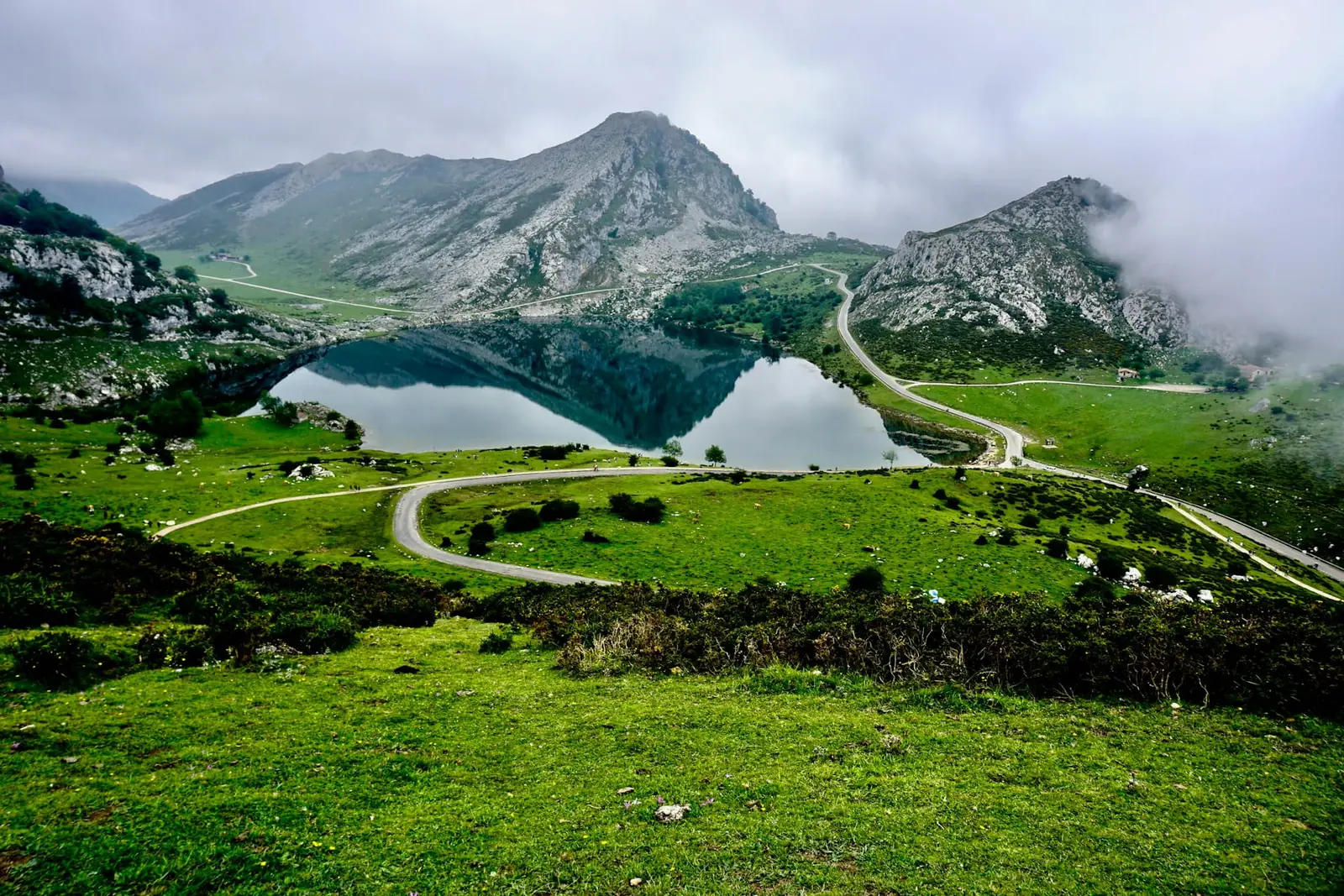 A glassy mountain lake reflecting the peaks of the Picos de Europa in northern Spain