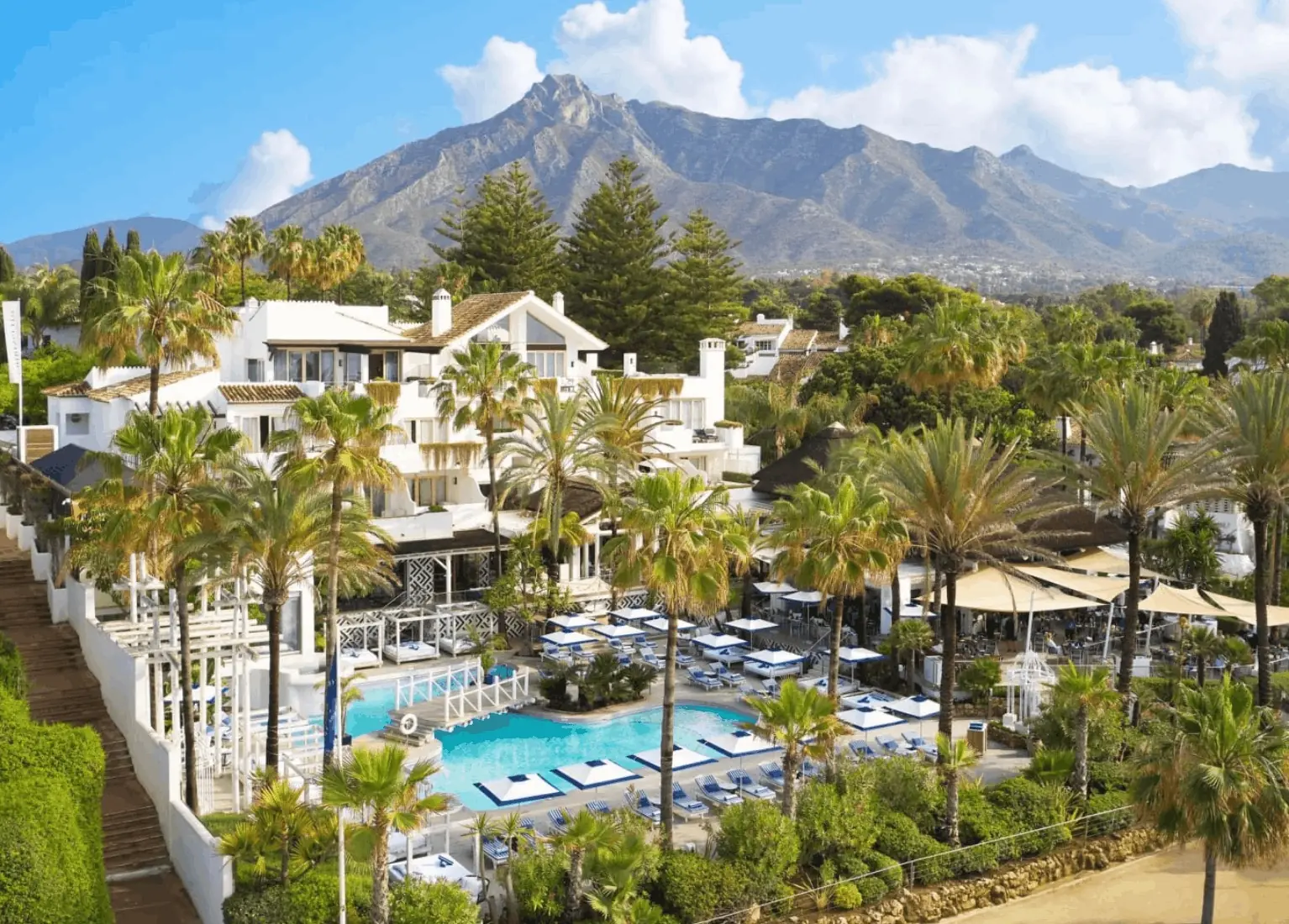 Puente Romano's whitewashed village resort with palms and pool beneath La Concha mountain in Marbella, Spain