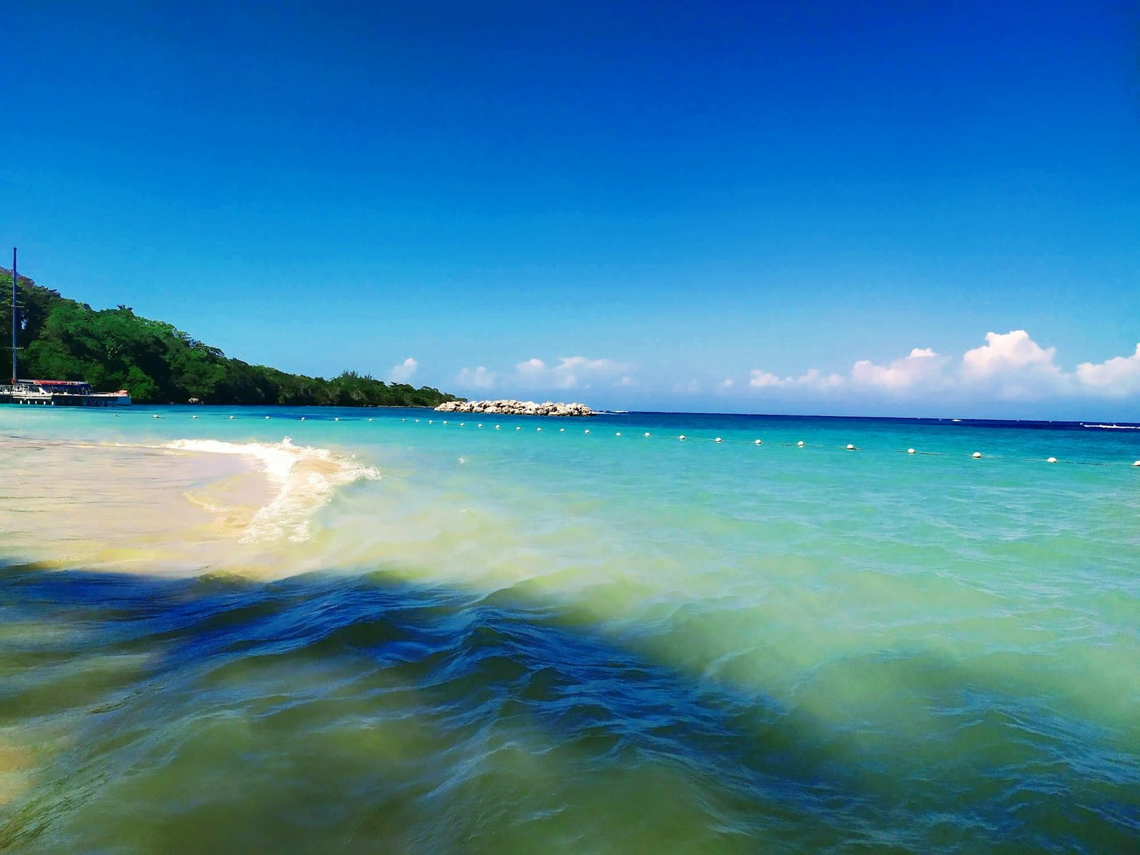 Turquoise Caribbean water and reef off a palm-fringed Jamaican beach