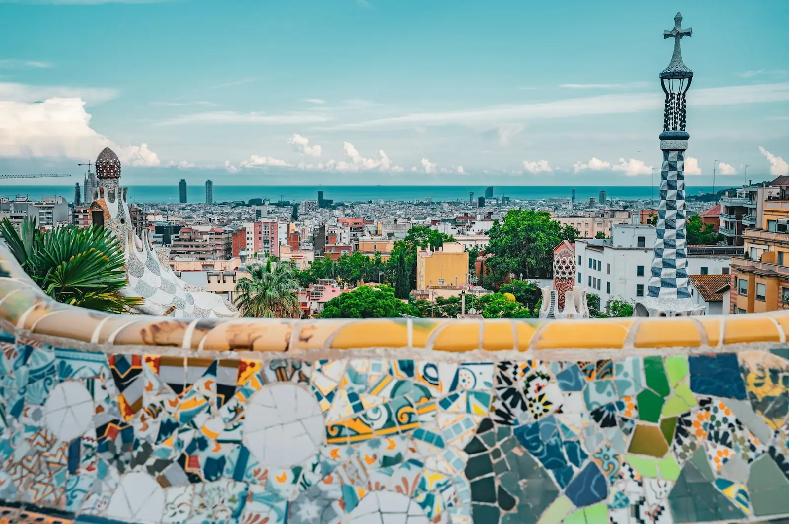 Gaudi's colourful mosaic terrace at Park Guell overlooking Barcelona and the sea, Spain