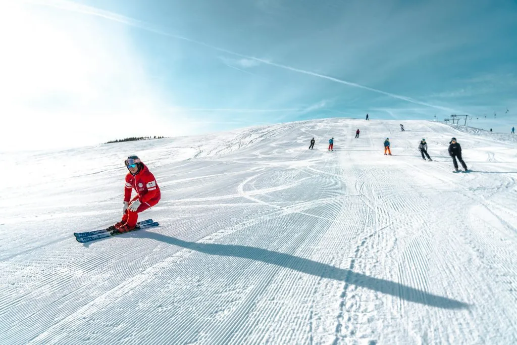 Skiers enjoy a bright winter day on the snowy slopes of Lombardia, Italy.