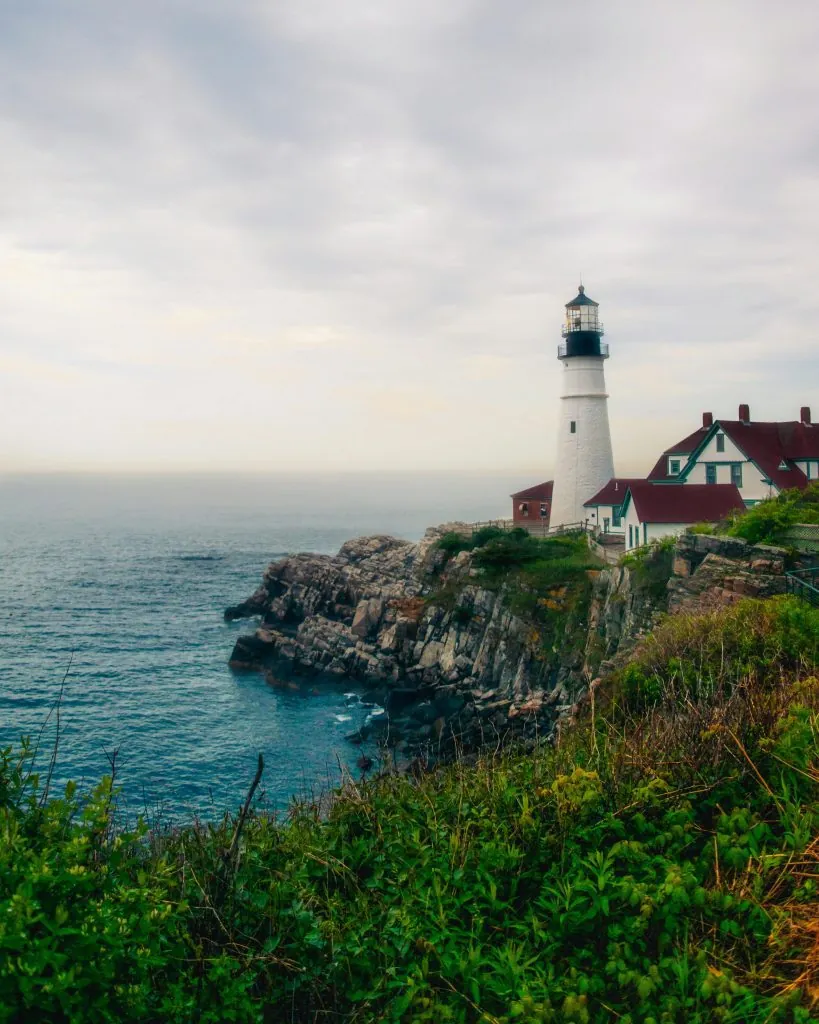 Scenic view of the iconic Portland Head Lighthouse on a rocky coast in Maine, USA.