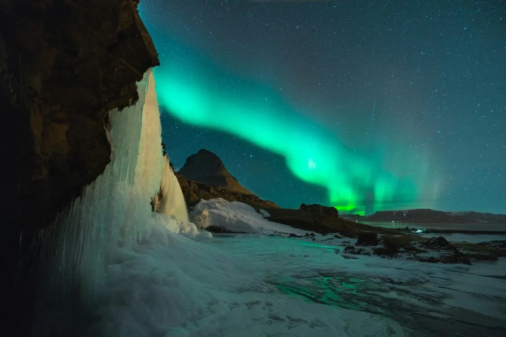 Rugged Icelandic landscape of mountains and a waterfall, ideas for what to do in Iceland