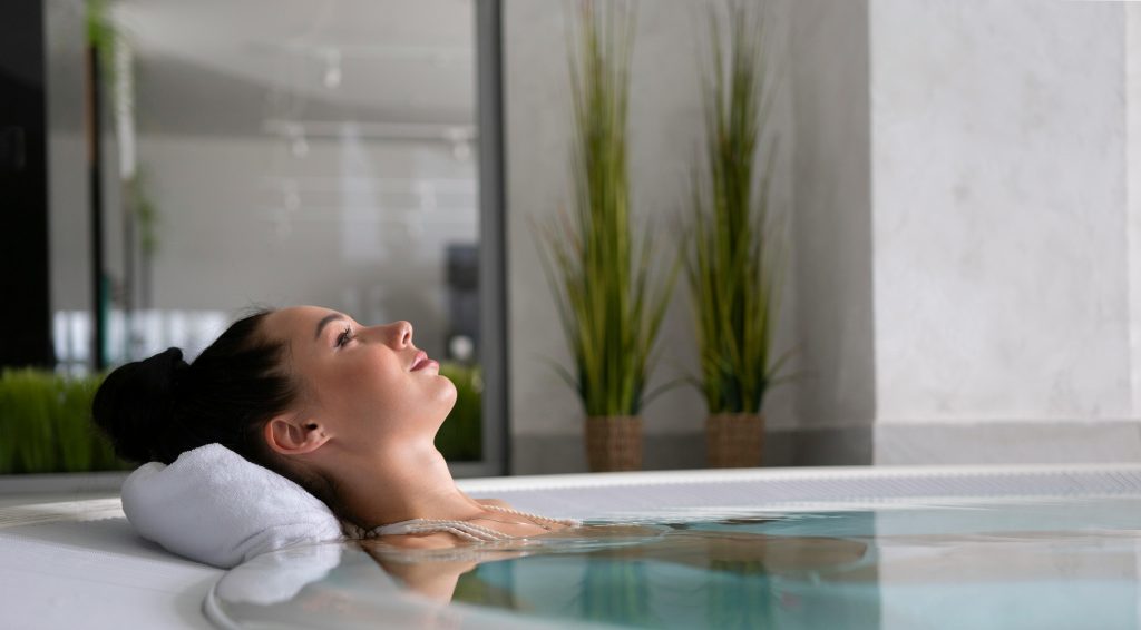 A woman enjoying a peaceful moment in a jacuzzi for relaxation and self-care.