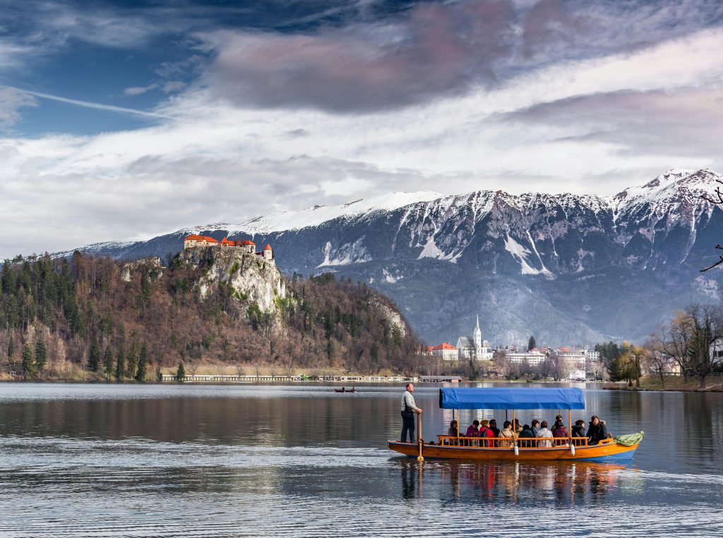 Pletna boat on Lake Bled with island and Julian Alps behind