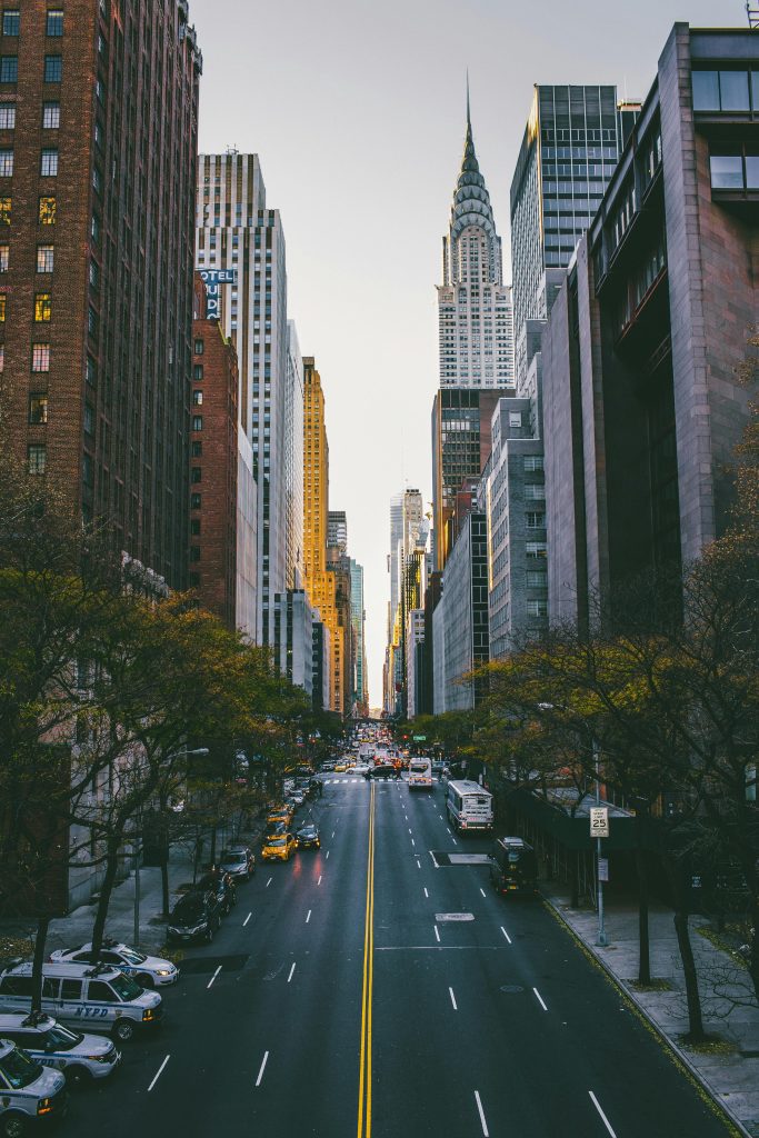 Stunning view of New York City's Midtown skyscrapers and busy street at dusk.